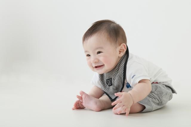 おすわりをしてほほえむ赤ちゃん
