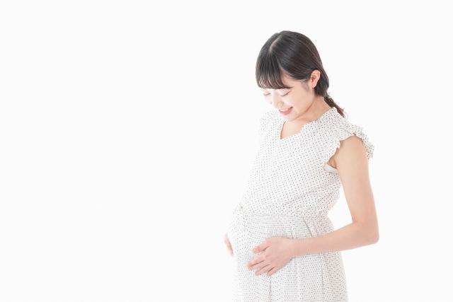 おなかに手を当ててほほえむ妊婦さん